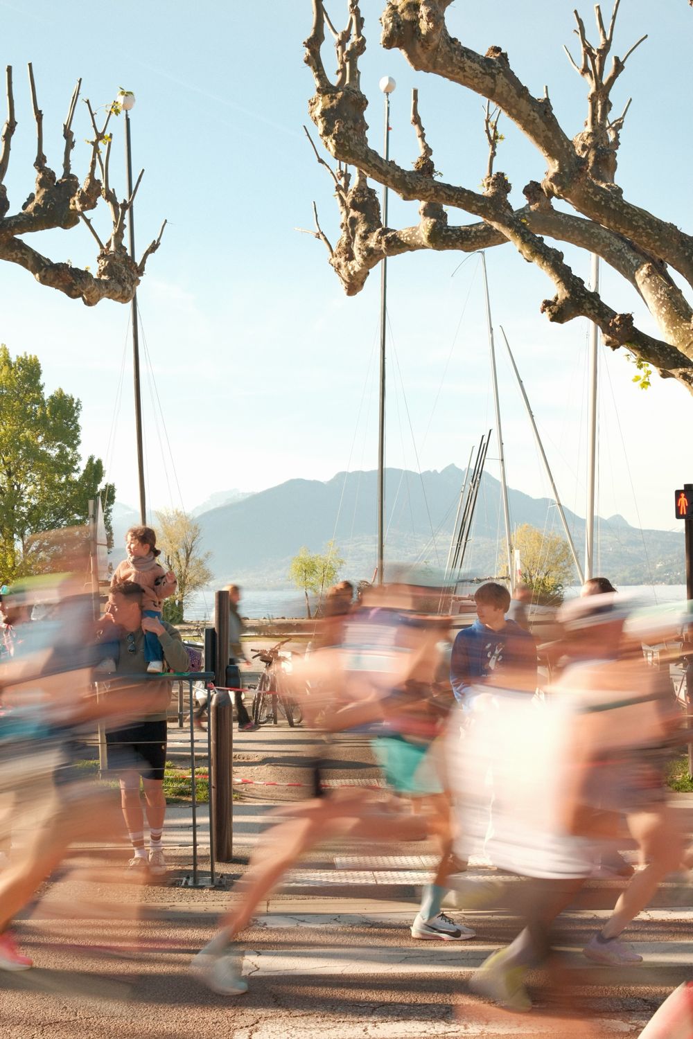 Coureurs à pied au bord d'un lac, montagnes en arrière-plan, flou de mouvement